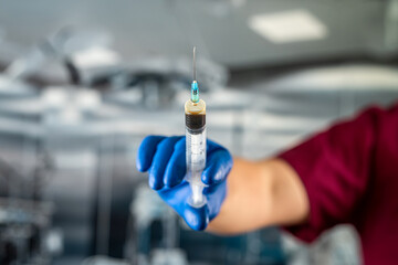 Hand holds syringe in  surgical office at the hospital