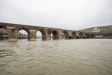 Fototapeta na wymiar Historical Diyarbakır ten-eyed bridge and reflection of the Tigris river