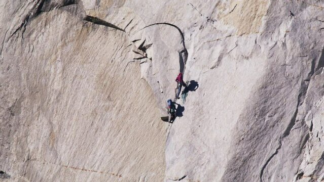 Breathtaking brave mountain climbers hanging on steep rock cliff at El Capitan 