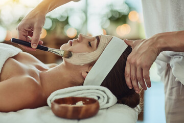Indulging in a deep cleansing masque. Shot of an attractive young woman getting a facial at a beauty spa.