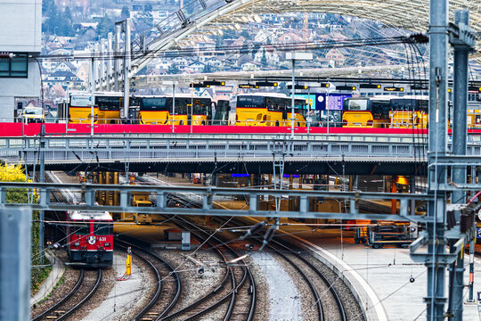 Postautodeck in Chur in Graub&uuml;nden in der Schweiz mit Bussen und Zug auf Schienen mit Glaskuppel-Dach oben