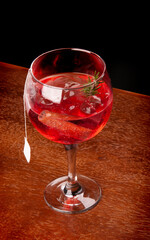 cocktail tea gin ice cinnamon and alecrin angle top view on wooden table