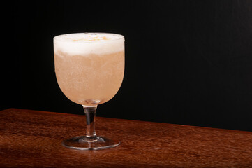 cocktail with ginger foam, lemon gin, angostura top view on wooden table corner