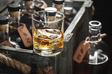 Glass of old whisky with ice in an old cellar.