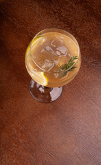 tropical cocktail glass of sicilian lemon with rosemary gin and ice on top view wooden table