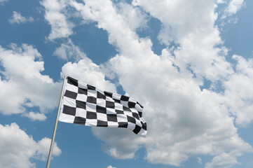 drapeau à damiers contre le ciel bleu nuageux