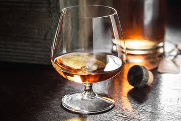 Old whisky with ice in a glass in the distillery.