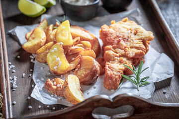 Homemade fish and chips with sauces and lime.