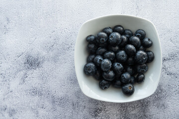 Delicious, tasty blueberries on a rustic background. Still life food photography. Blank space left around the berries for your text.