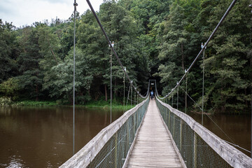 A cyclist crosses a suspension bridge