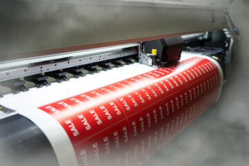 Printing of sale stickers on a printing press. Full-color printing in production.
