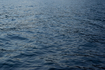 Close-up blue sea background. A backing with sea waves texture for branding, calendar, postcard, screensaver, wallpaper, poster, banner, cover, website. A place for your design or text