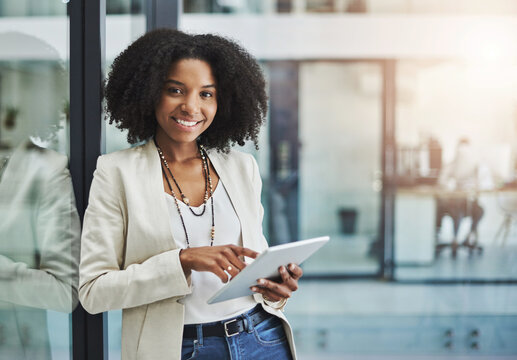 Make it your business to be tech savvy and industrious. Portrait of a young businesswoman smiling and holding a digital tablet in her office.