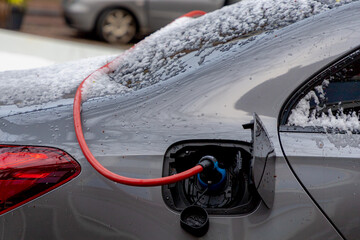 Power supply connect to electric vehicle for charging battery, Charging an electric car in public...
