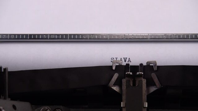 Typing Ukrainian greeting and slogan "SLAVA UKRAINI ! HEROIAM SLAVA !" on retro typewriter.
