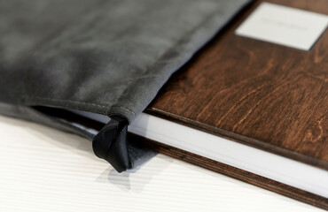 A beautiful and stylish modern wooden photo book standing on a table against a light background. photo album for memory. fabric book cover