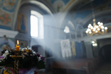 Light through the window to the church. Memory candle. holy light. Box of essential oils. Holy water. Gospel.