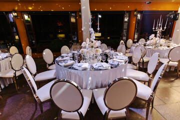 Wedding decor. Wedding interior. Festive decor. Restaurant interior. The burning candles on a table.