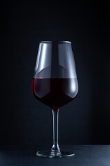 Closeup of a red wine glass against a dark background