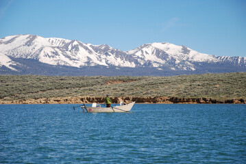 Anglers fishing from a drift boat with mountains in the background  © Verbbaitum