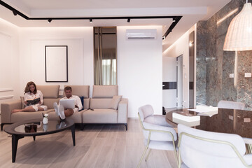 A modern family enjoys a vacation in their luxury home. The family spends time on modern devices, tablets and laptops. Selective focus 