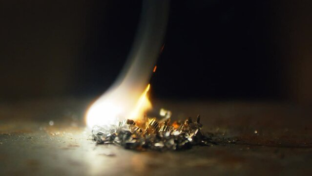 Light the flame with flint. Metal shavings catch fire and burn. Tries to start a fire with a flint. Slow motion. High speed camera. 4K video. Shot on RED