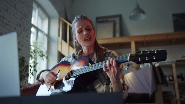  Woman singing and playing guitar during video call