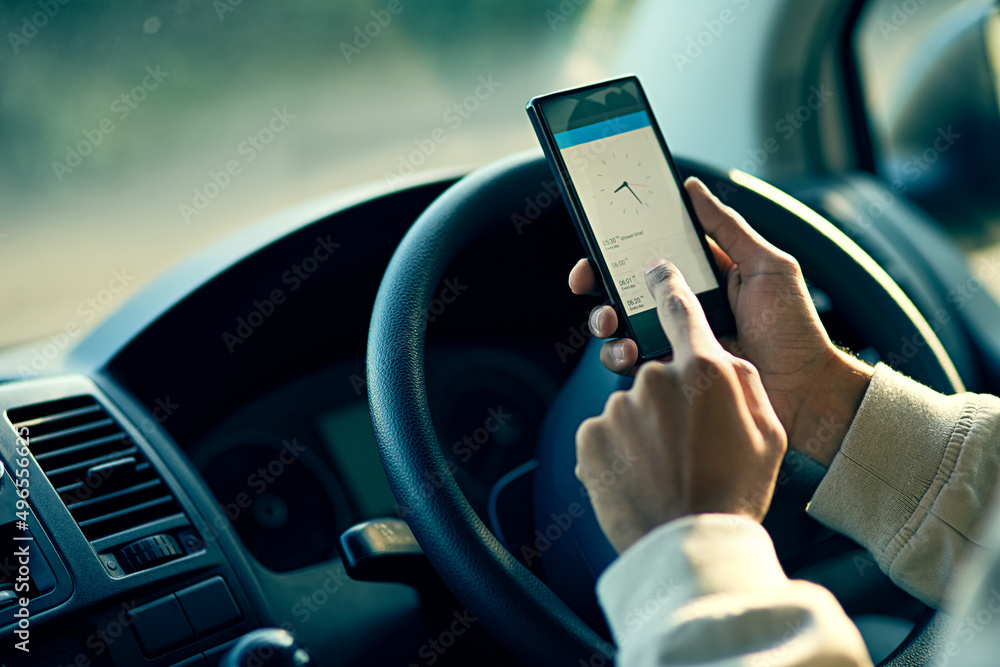 Poster Staying on schedule. Closeup shot of an unidentifiable delivery man using a cellphone while sitting in his van.