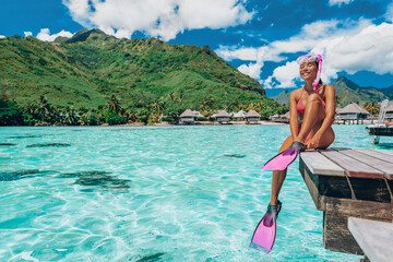 Beach Luxury Travel Vacation in Tahiti. Snorkel swim woman going snorkeling in coral reefs of French Polynesia ocean in overwater bungalow resort with snorkelling mask, fins. Christmas winter getaway - obrazy, fototapety, plakaty