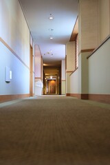 誰もいない明るい奥に向かうホテルの廊下