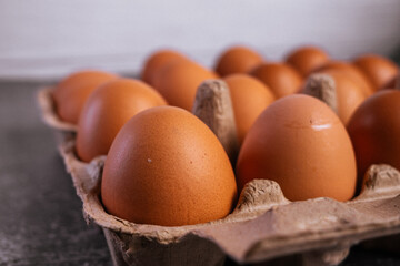 chicken eggs in an open egg carton. Fresh chicken eggs background.
Top view with copy space. Natural healthy food and organic farming concept. Eggs in box