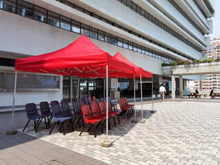 red rain and weather tent or canopy and chair for meeting in open area