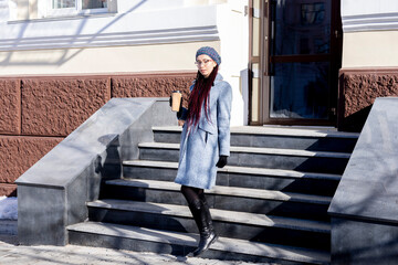 Young Asian girl eco-friendly . Reusable glass for hot drink. Walk on the street.