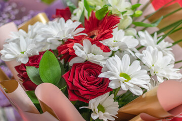Beautiful flower bouquet of white daisies and red roses. A beautiful gift for newlyweds.