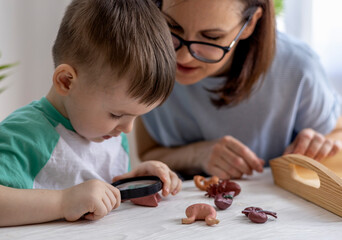 Montessori material. Schoolboy plays doctor at home.