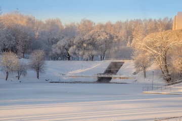 beautiful city park covered with snow blanket on winter frosty morning