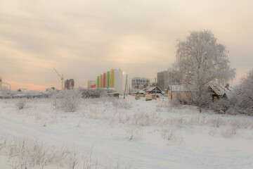 new high-rise buildings are being built against the background of old wooden houses