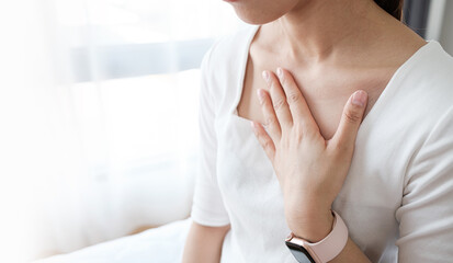 Young woman putting her hand on her chest. Having a pain in chest, Gastroesophageal Reflux Disease  have frequent belching. Healthcare medical concept. - obrazy, fototapety, plakaty