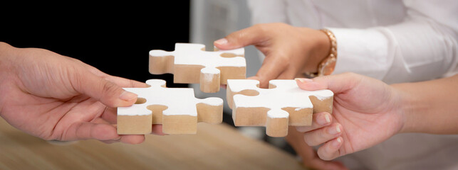 Hands of team young business and partner holding piece jigsaw for assembly is metaphor, teamwork...