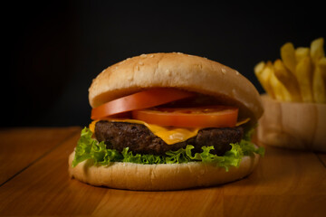 Fresh hamburger and french fries on black background