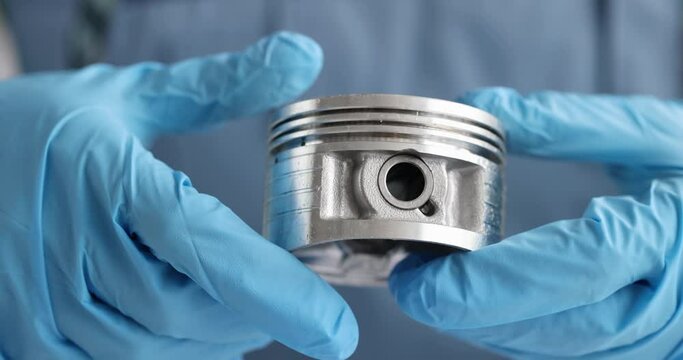 New engine piston in hands of mechanic