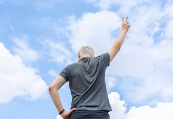 Fototapeta na wymiar Guy standing against the sky, rear view