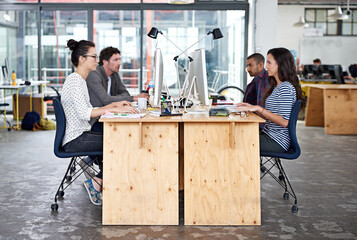 Make creativity a job. Shot of a group of young office workers sitting at their work stations.