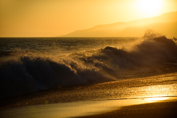 Golden sunset at the sea. landscape with sunset over the ocean. Gold sky and ocean water. Waves splashes.