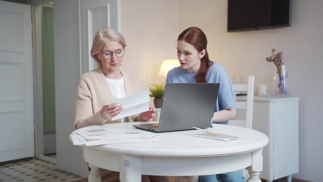  Daughter helps her elderly mother pay bills online