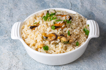 Mussel rice pilaf. Rice with mussels on small white plate on ceramic. (Turkish name; midyeli pilav)