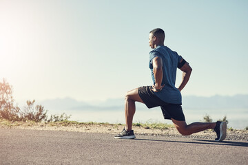 Lunging is good for the legs. Shot of a young handsome man doing lunges outdoors.
