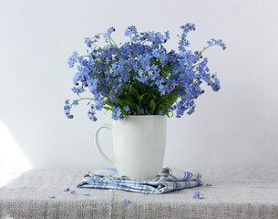 bouquet of blue forget-me-nots in a white mug