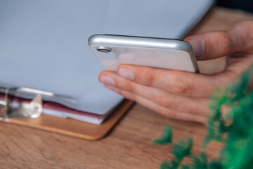 hand with mobile phone on desk