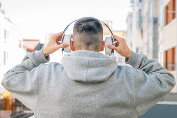 head of young man with headphones on his back in the street